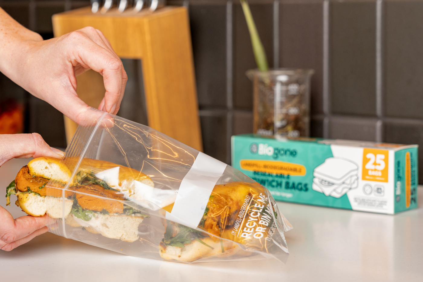 category page featured image (3) Packing a sandwich into a resealable sandwich bag from Biogone on a kitchen counter.